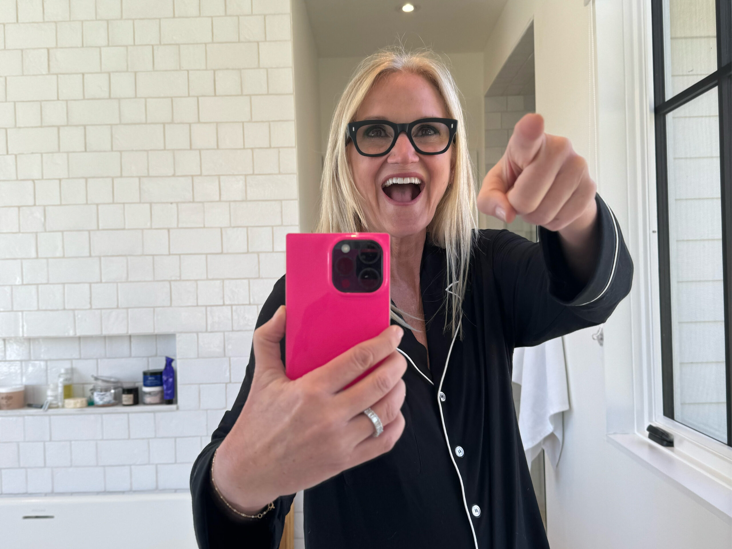Mel Robbins photo of herself in mirror, smiling and pointing and herself